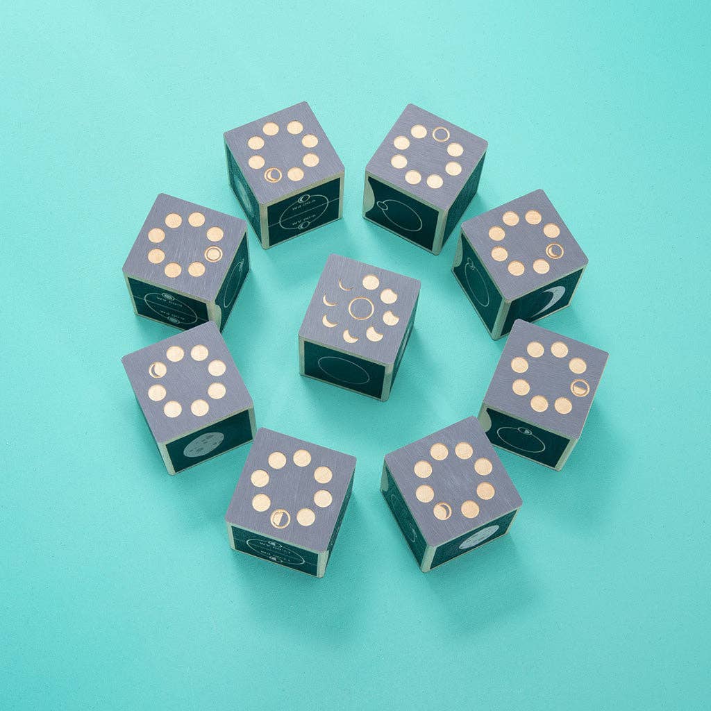 Nine Uncle Goose Moon Phase Blocks—blue cubes featuring gold dots and detailed moon phase icons—are arranged in a circle on a teal background.