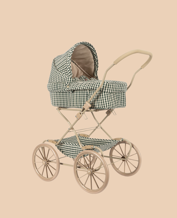 The Konges Sloejd Doll Pram - Smoke Pine Checkered is a vintage-style stroller with a beige frame, large spoked wheels, padded mattress and basket, and green-and-white checkered quilted fabric, shown against a plain beige background.