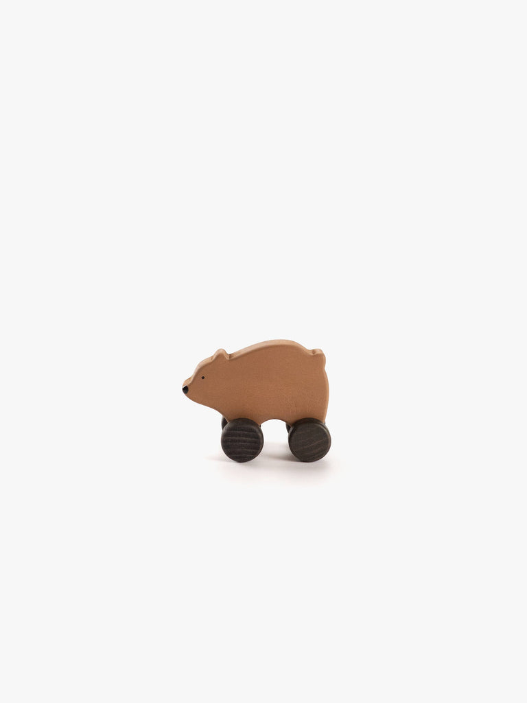 The Sabo Concept Wooden Rolling Brown Bear, a small wooden toy with black wheels for legs, is shown against a white background—ideal as a Montessori toy.