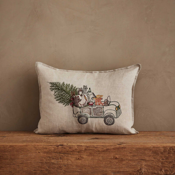 The Coral & Tusk Christmas Tree Car Pocket Pillow features embroidered woodland animals riding in a car with a Christmas tree, making it the perfect festive accent for your holiday decor.