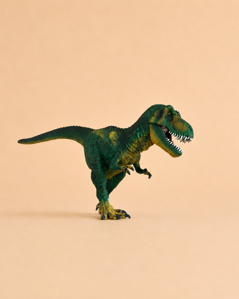 The Schleich Tyrannosaurus Rex Dinosaur Toy with Movable Jaw, made from green plastic, stands on a beige surface with a plain beige background.