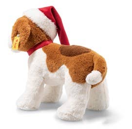 The Steiff Snuffy Puppy Dog Plush with a Santa Hat is adorned with a brown and white coat and features a festive red hat paired with a matching collar. A small tag hangs from its ear as it faces sideways to the left, making it perfect for holiday cuddles.
