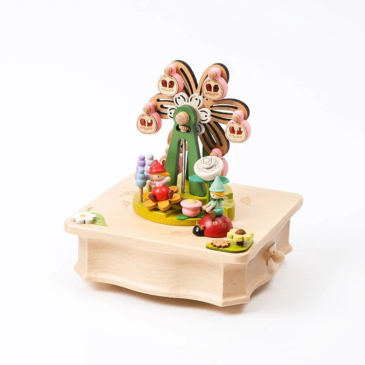 A colorful Ferris Wheel Fairy Music Box featuring a flower design with numbers and bees, set on a sturdy base with various shaped blocks scattered around, crafted from sustainably sourced wood.
