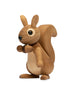 A Spring Copenhagen Hazel squirrel figurine, crafted from FSC Oak with visible wood grain and joints, stands upright against a white background. The squirrel holds an acorn and has large, expressive black eyes.