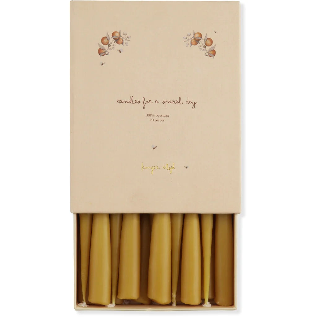 The "Magical Forest Birthday Train With Beeswax Candles" comes in a beige box with acorn and leaf designs, containing 20 neatly arranged tapered beeswax candles—ideal for celebrating a special day.