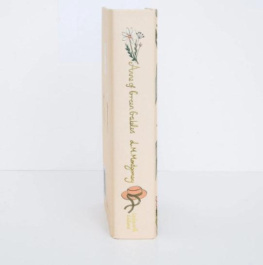 The spine of the Collector's Edition Hardcover of "Anne of Green Gables" features a white flower and a hat with ribbons on a light cream background.