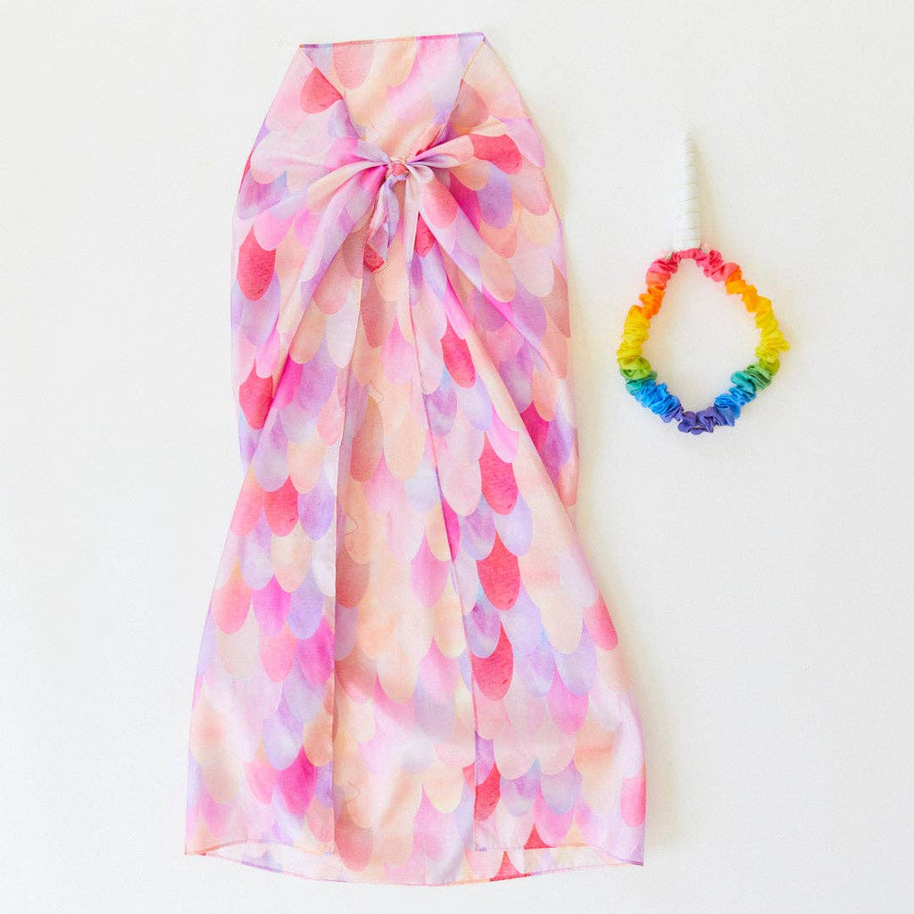 Sarah's Silks Magical Creatures Playsilk - Pink Unicorn is displayed flat beside a rainbow elastic headband with a white unicorn horn, all set on a plain white background—ideal for imaginative play.