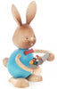 A Collectible Dregeno Easter Figure - Rabbit With Egg Carton, handcrafted in Germany, with a blue body and a red bow tie, holding a carrot with colorful details, standing upright on a white background.