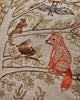 The Coral & Tusk Woodland Living Tree Pillow features embroidered woodland animals—a fox, bat, squirrel, two birds in a nest—and leafy branches. Ships in one week.