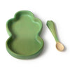 Kendall the Kale Plate & Spoon Set features a bear-shaped, green baby dinnerware plate crafted from sustainable Hevea wood with curved, non-toxic edges, paired with a matching green spoon. The spoon boasts a leaf-inspired handle and a light-colored, round end. Both pieces are elegantly displayed on a white background.