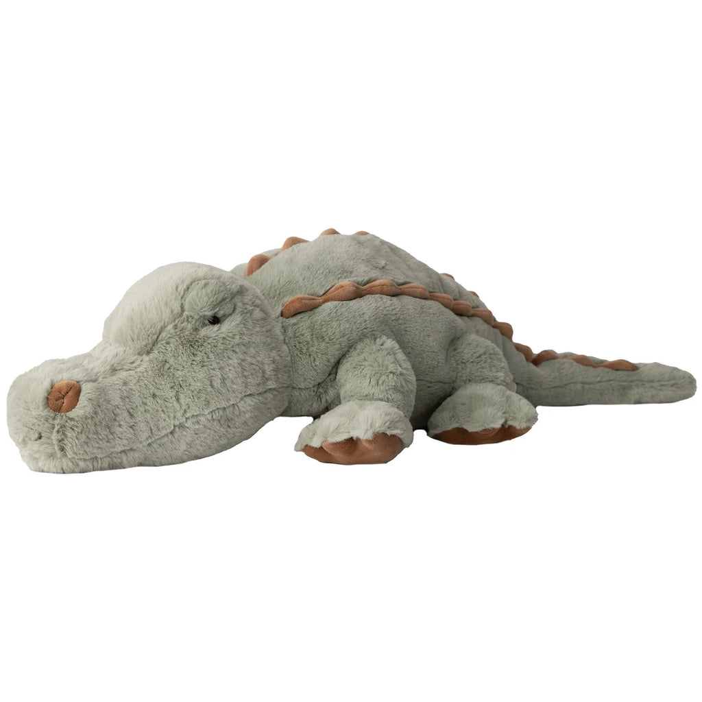 Bukowski - The Great Maximus Alligator is a light green plush toy with brown accents on its feet, back, and nose, featuring a relaxed, friendly look as it lies flat on its stomach.