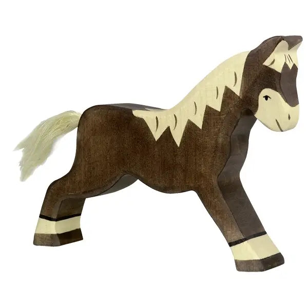 A Holztiger Horse, Running, Dark Brown, this wooden horse figurine boasts a natural brown finish and lighter tan accents on its mane, tail, and legs. The horse is in a walking pose, and its simple design underscores the handcrafted quality made in Europe, giving it a rustic charm.