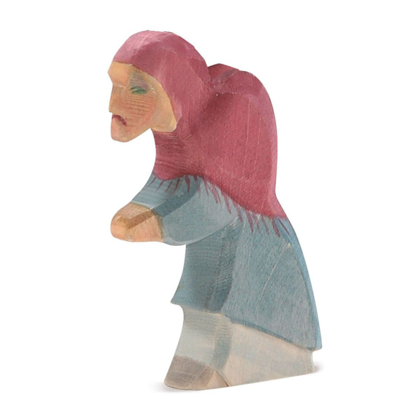 The Ostheimer Witch is a handcrafted wooden figurine that depicts a person wearing a red hood and blue clothing, with visible facial features and one arm extended forward. This rustic, hand-carved piece is ideal for imaginative play, evoking the charm of classic Ostheimer wooden toys.