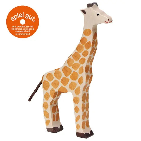 A Holztiger Giraffe with a white body and orange spots stands upright. It features a simple, handcrafted design typical of HOLZTIGER figures. An orange circle with the "spiel gut" certification mark is displayed in the top left corner.