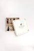 A white Sabo Concept Christmas Ornaments gift box with a rocking horse lid design, partially open to show six hand-painted wooden ornaments nestled in shredded white paper.