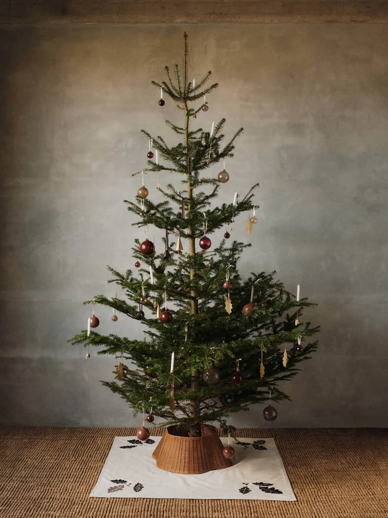 A Christmas tree decorated with round ornaments and a set of 4 Ferm Living Oak Leaf Ornaments - Brass.
