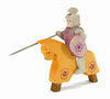 The Ostheimer Red Knight - Riding toy, dressed in gray armor and a purple shirt, holds a lance and shield while riding an orange horse adorned with floral designs. The knight's smiling face invites imaginative play as the handcrafted wooden toys come to life on four sturdy legs.