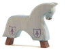 The Ostheimer Blue Horse for Knight is a light blue, handcrafted wooden horse figurine with brown legs and simple facial and body details. This minimalist design features two shield shapes, each containing a fleur-de-lis, painted on its side. It stands gracefully on a white surface.