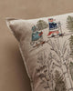 The Coral & Tusk Winter Fun Pillow showcases woodland animals—a cat and a fox—skiing in cozy outfits among green trees and bare branches on beige fabric, making it perfect for festive holiday decor.