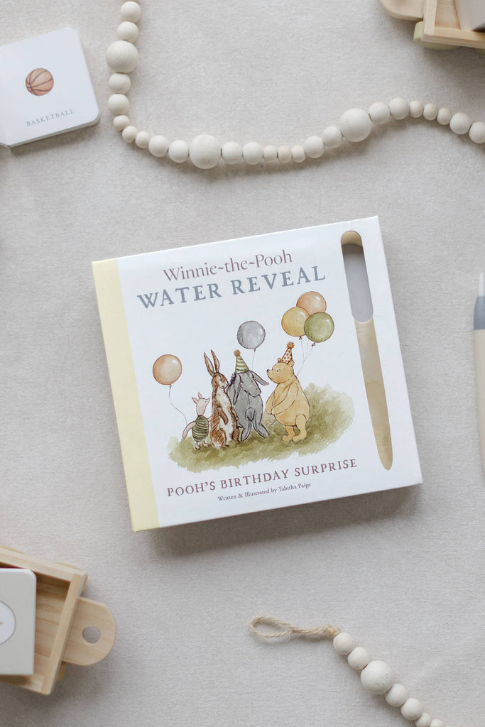 Winnie-the-Pooh: Pooh’s Birthday Surprise (Water Reveal) book featuring Pooh, Piglet, Eeyore, and Rabbit wearing party hats and holding balloons, with an attached water pen for this no-mess activity.