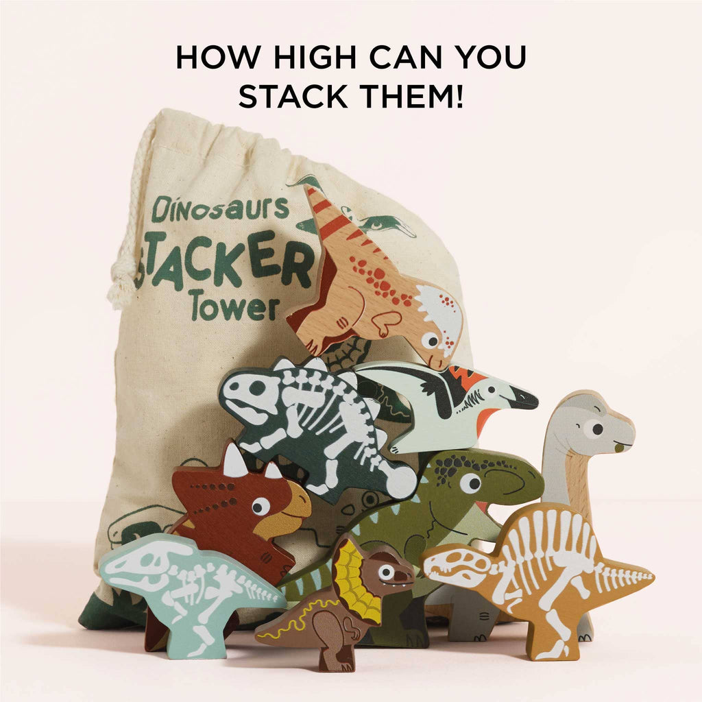 A vibrant set of FSC-certified wooden dinosaur toys is stacked in a pyramid shape before a cloth bag labeled "Jurassic Stacking Dinosaurs." Text above asks, "How high can you stack them?" This plastic-free toy challenges and delights the imagination.