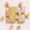 The ABC Learning Blocks (ships in one week) is a wooden puzzle board with pastel letter and shape blocks, offering toddlers a fun and educational way to learn the alphabet and patterns on a light background.
