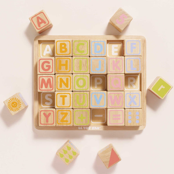 The ABC Learning Blocks (ships in one week) is a wooden puzzle board with pastel letter and shape blocks, offering toddlers a fun and educational way to learn the alphabet and patterns on a light background.