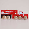 A red wooden toy truck labeled “No. 33 GT180 Toby | Made in England” with six wheels and white decorative bubbles, this wooden cola truck features a charming vintage-inspired design, perfect for imaginative storytelling and pretend play as a classic cola delivery vehicle.