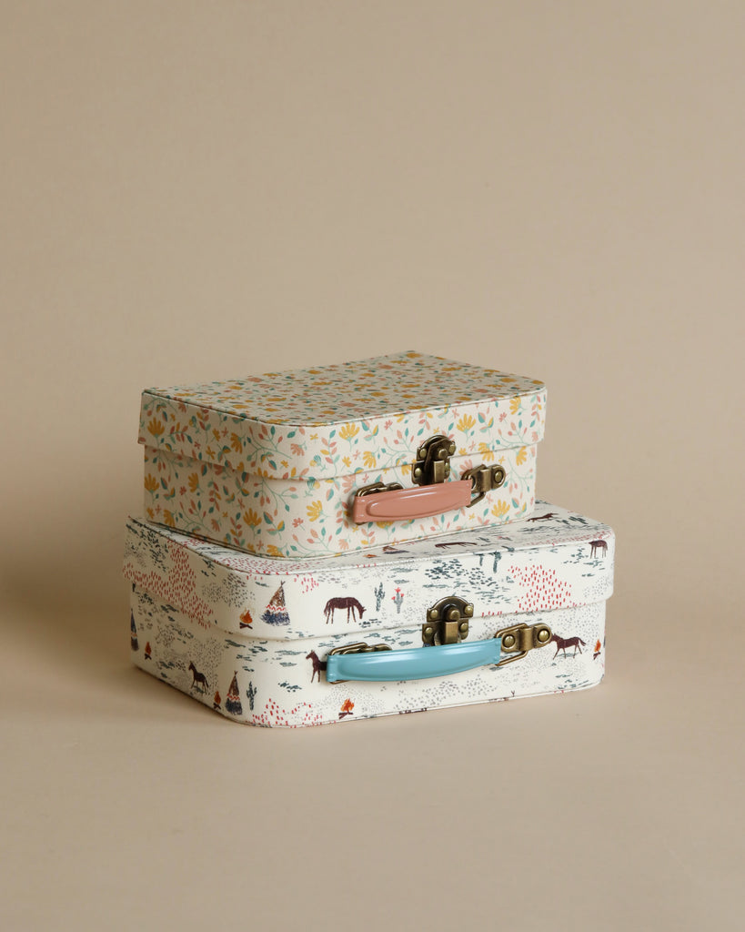 Two beautiful Maileg 2 Piece Suitcase Sets with floral and animal fabric prints stacked on a beige background.