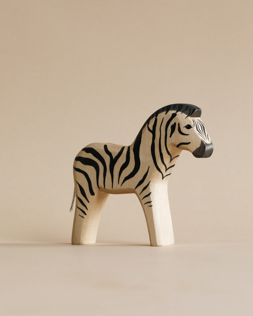 A high-quality Handmade Holzwald Zebra with black and white stripes, standing on a soft beige background. The figure is depicted with a realistic zebra pattern and a stoic expression.