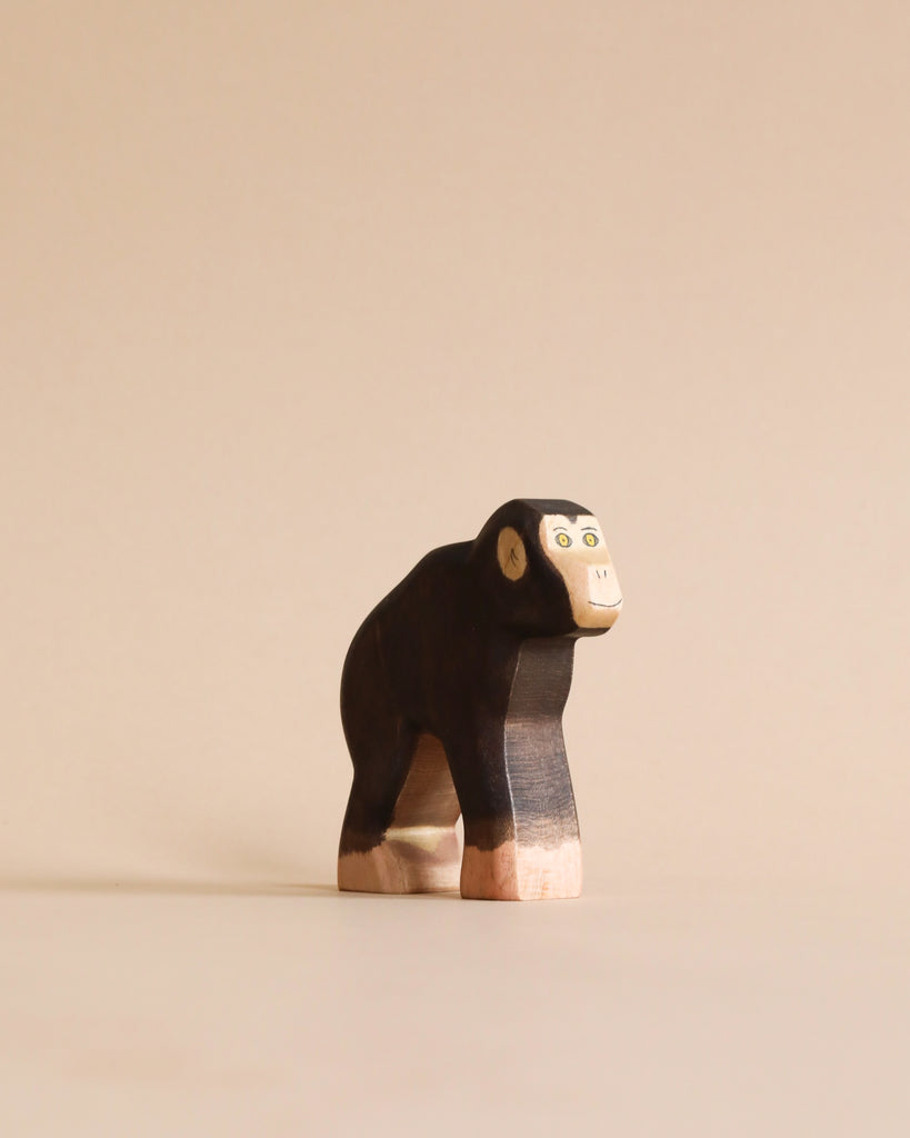 A handmade Holzwald Chimpanzee figurine painted black and white, standing against a plain beige background.
