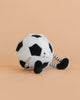 A Mon Ami Soccer Ball Set plush toy featuring a smiling face, rosy cheeks, and striped arms and legs, displayed on a light peach background.