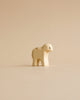 A Handmade Holzwald Lamb Standing figurine against a plain beige background, showcasing minimalist design with soft curves and a neutral palette. This piece exemplifies sustainable toys with its environmentally friendly materials.