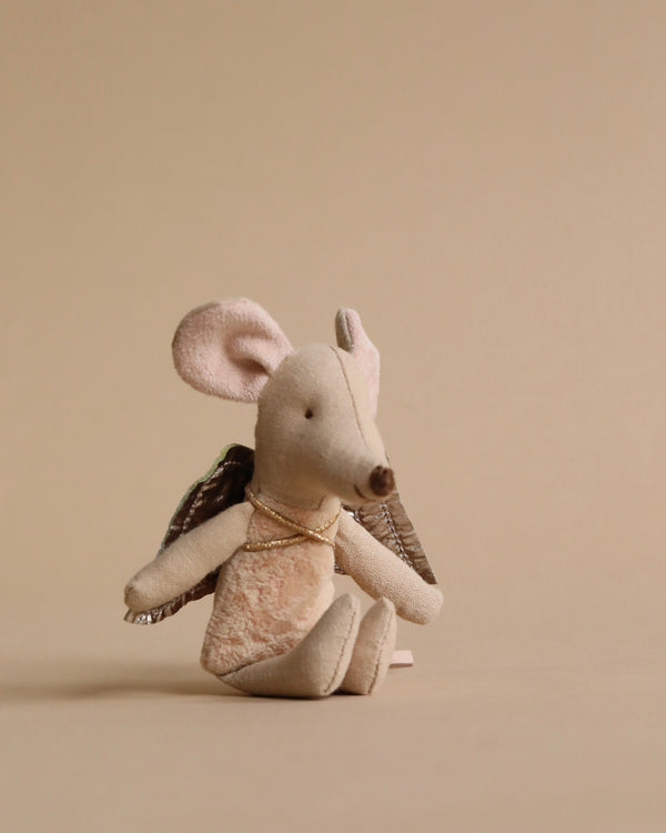 A Maileg Fairy Angel Mouse - Powder with large ears and a delicate pink nose, dressed in a small brown jacket, sitting against a plain beige background.