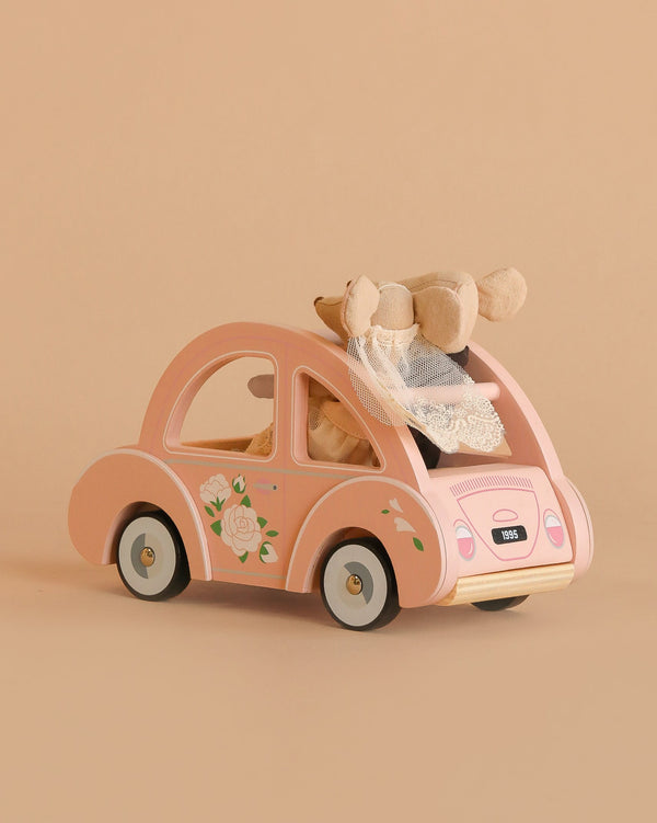 The Maileg Just Married Set features a small pink toy car with floral designs, carrying two wedding mice as bride and groom—perfect for display in Sophie's Dolls House.
