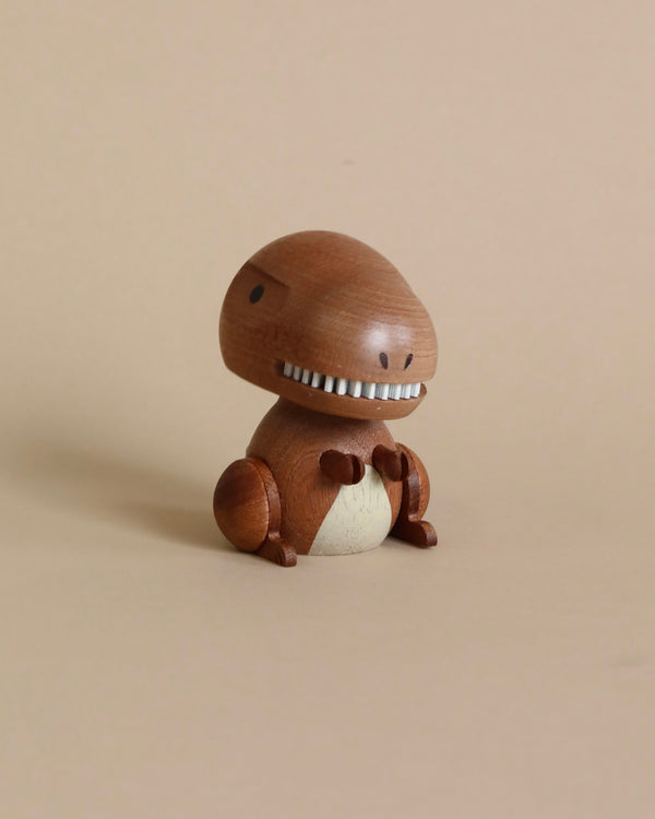 A wooden T-Rex bobblehead shaped like a whimsical creature resembling a mushroom, featuring a rounded cap for a head with a zipper-like smile and small arms and legs, sitting against a plain beige background.