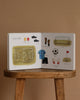The Sports Storytime Set features an open preschool sports book on a wooden stool, displaying labeled soccer illustrations—field, cleats, shin guards, goal, ball, and more—to help build kids’ sports vocabulary.