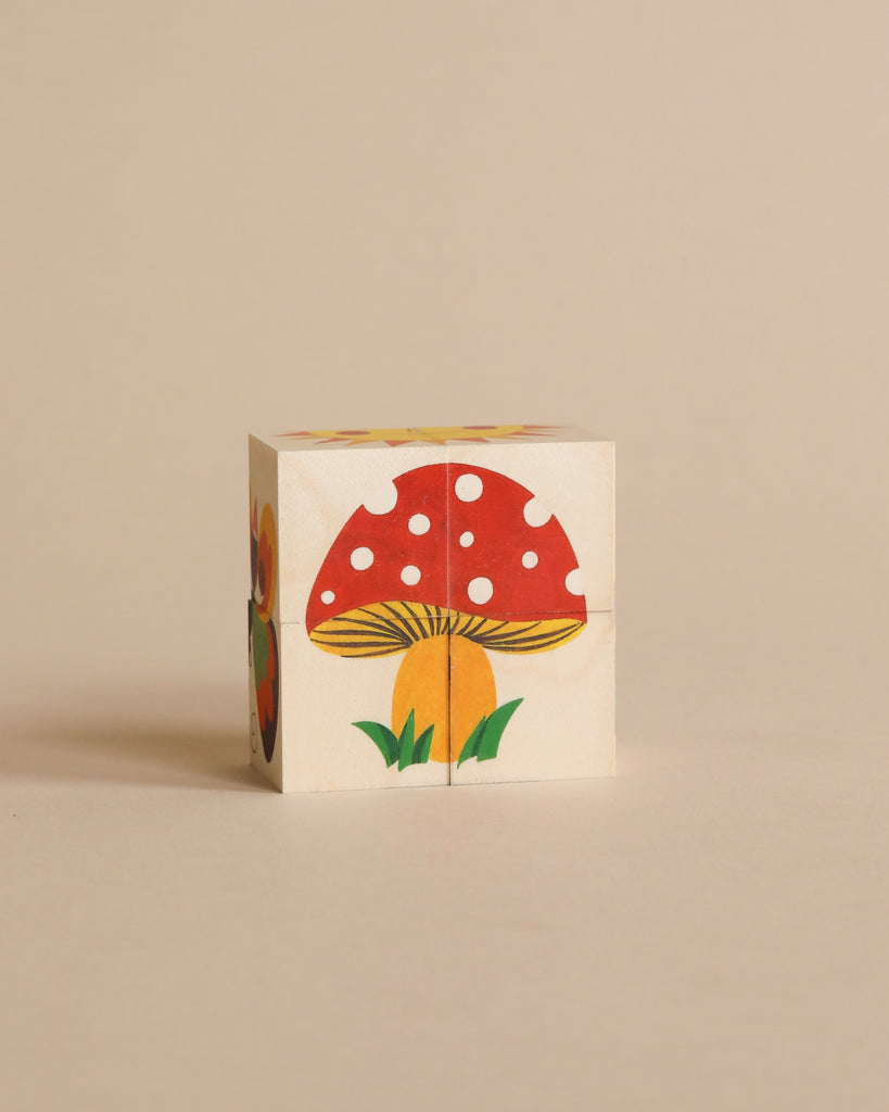 A Wooden Block Puzzle - 4 Piece Woodland painted with a vibrant illustration of a red mushroom with white spots and green foliage on a neutral background.