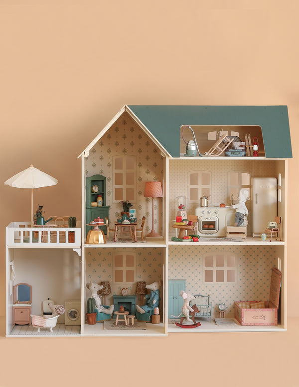 The Maileg Fully Furnished Dollhouse Set + Surprise Gift (ships in one week) features six vintage-style rooms with charming furniture, a miniature bathroom, and playful animal figures posed throughout.