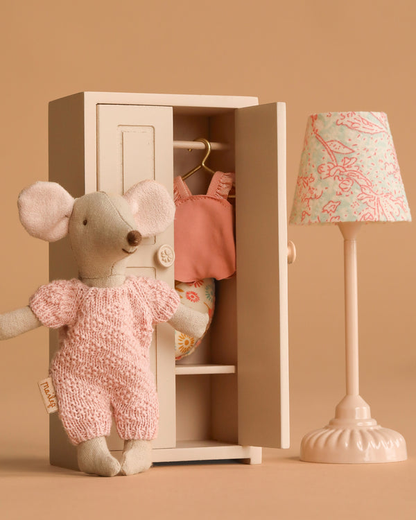 The Maileg Springtime Wardrobe Set features a beach mouse in pink overalls, a closet with clothes, and a vintage floor lamp, all arranged against a beige background.
