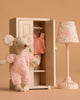 The Maileg Springtime Wardrobe Set features a beach mouse in pink overalls, a closet with clothes, and a vintage floor lamp, all arranged against a beige background.