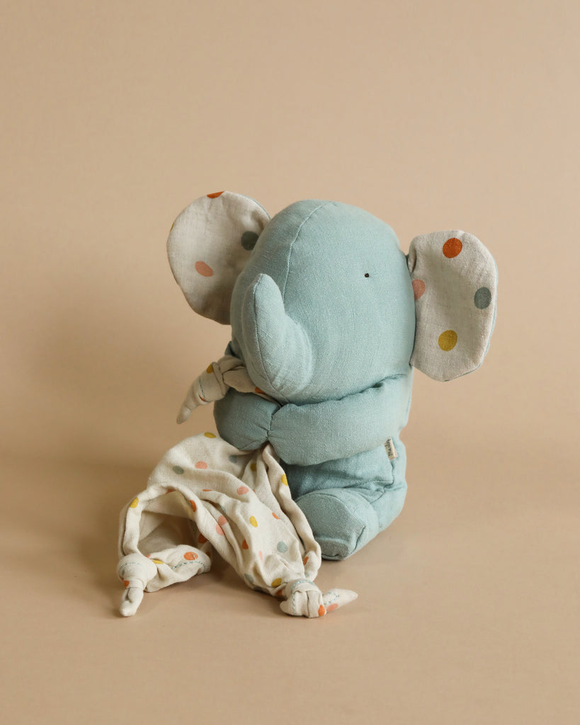 A Maileg Lullaby Friends - Elephant (Plays Music) in a light blue color with a patterned blanket draped over its back, sitting against a plain beige background, ideal for baby gifts.