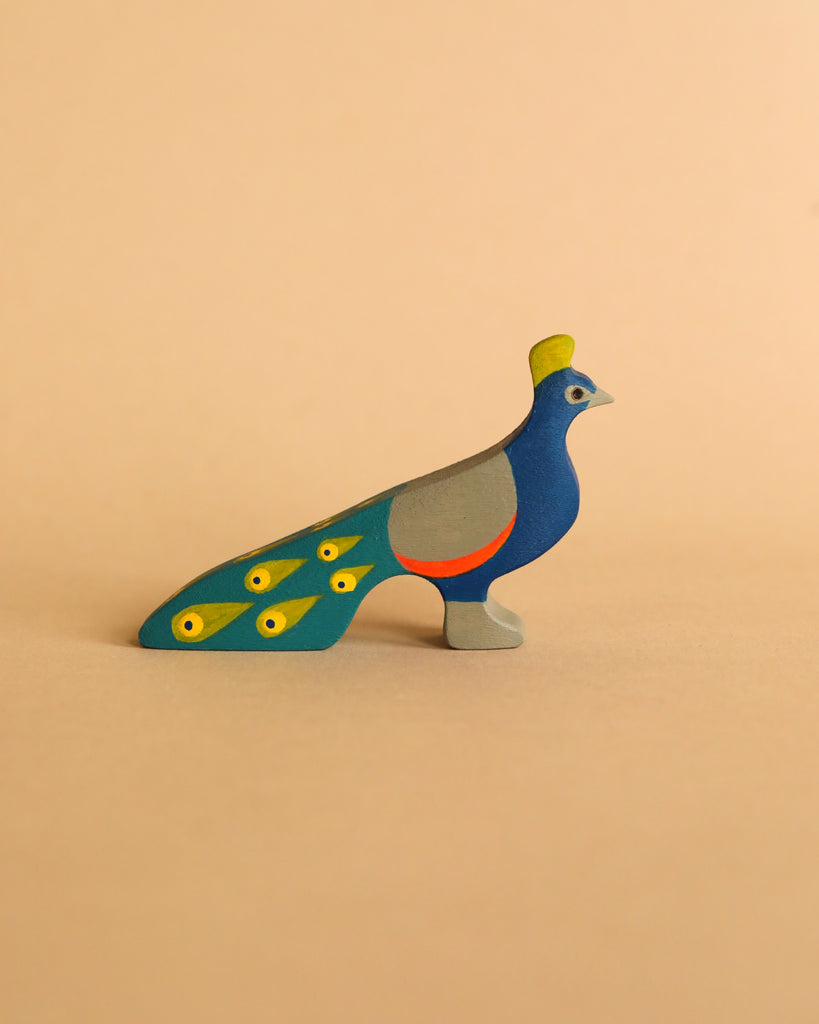 The Handmade Wooden Peacock is a handpainted toy adorned with vibrant blue, green, and yellow hues set against a beige background, making it ideal for small world play.