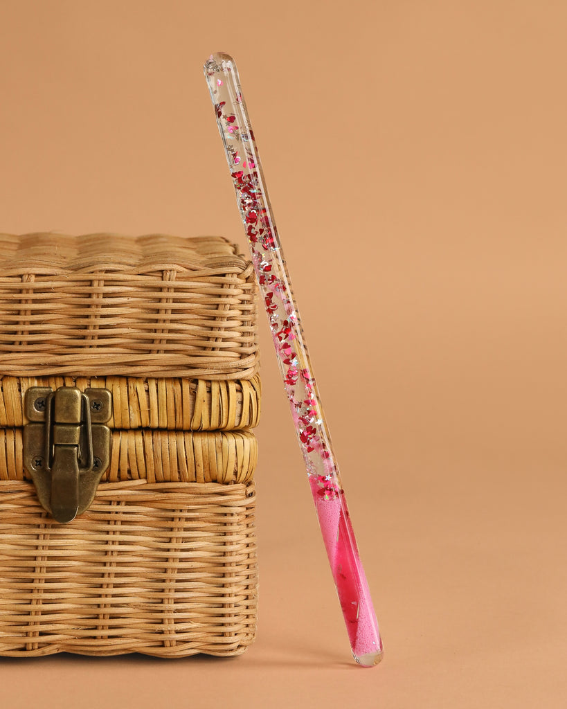 The Konges Sloejd Magical Glitter Wand - Pink Mix is a sparkling, wand-shaped box with pink liquid—ideal for kids who love imagination and a touch of glittery magic.