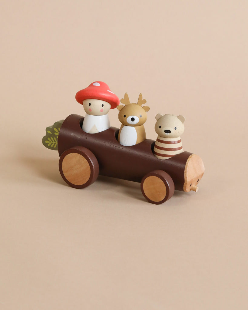 A Timber Taxi wooden toy car with a mushroom, a deer, and a bear figurine on a beige background.