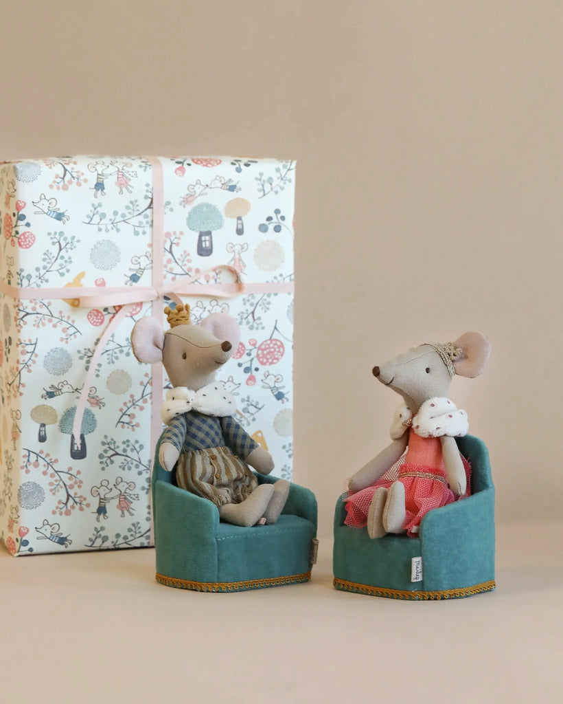Two adorable Maileg Royal Mice Set - Gift Wrapped, one dressed as a prince in a striped outfit and the other as a princess in a polka dot dress, sitting in small fabric boxes near a larger gift-wrapped