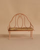 The Maileg Vintage Bench, Mini - Dark Powder, is a small ornate bench with a rounded backrest and armrests, painted dark powder pink and featuring a floral-patterned cushioned seat, set against a beige background.