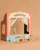 The Maileg Family Theater Set creates a magical scene with tiny mice—one performing on stage, an acrobat above, and four seated on Maileg dollhouse furniture. The beige background enhances this enchanting toy theater display.
