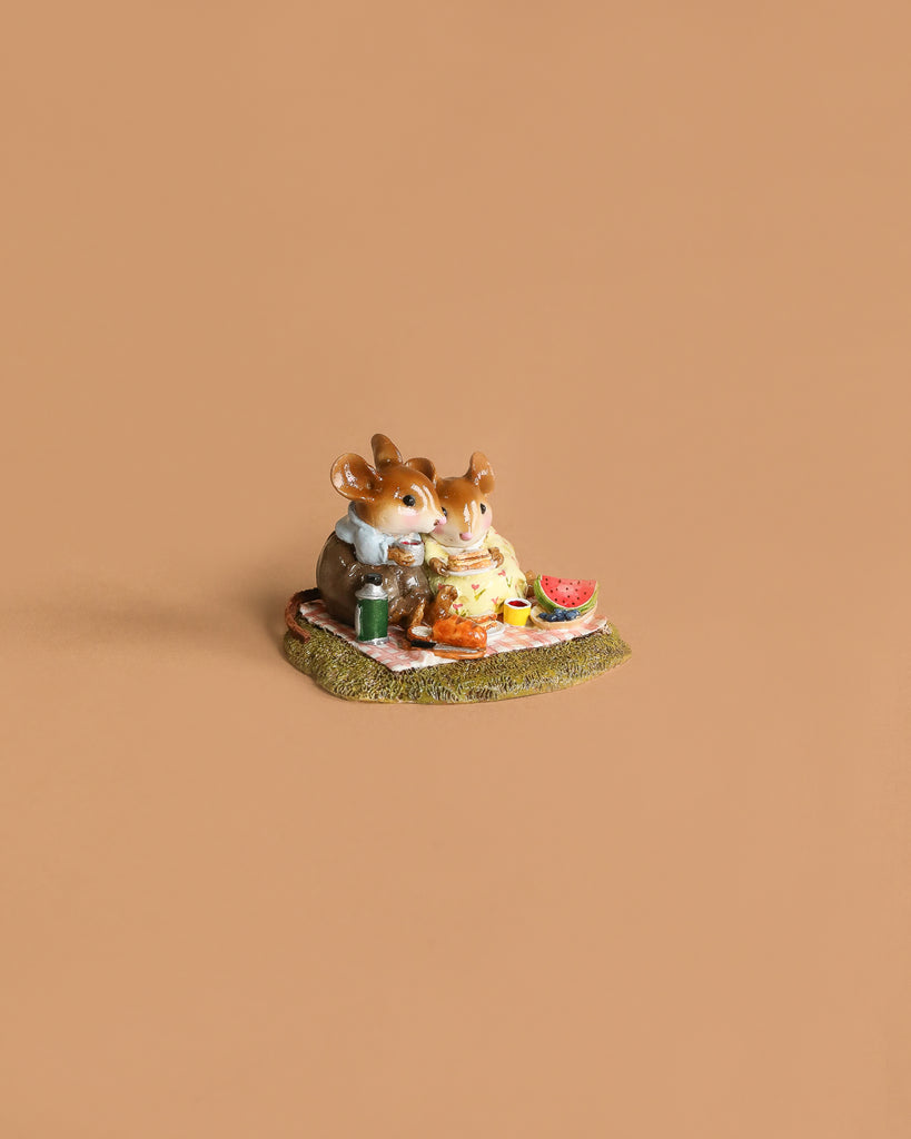 The Wee Forest Folk Tiny Collectible - Just the Two of Us features two handmade mouse figurines sharing a picnic with watermelon on a blanket, evoking the charm of hand-sculpted miniatures.