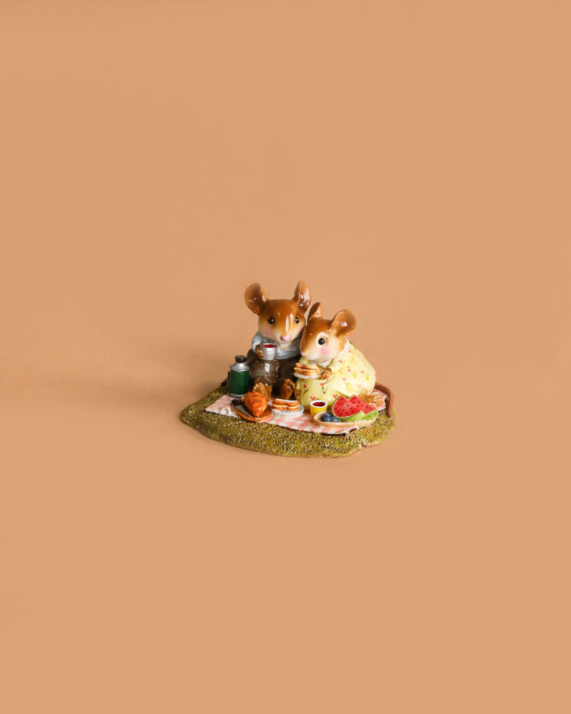 The Wee Forest Folk Tiny Collectible - Just the Two of Us features two handmade mouse figurines on a grassy patch, sharing a picnic with food and a teapot on a blanket, set against a plain tan background.